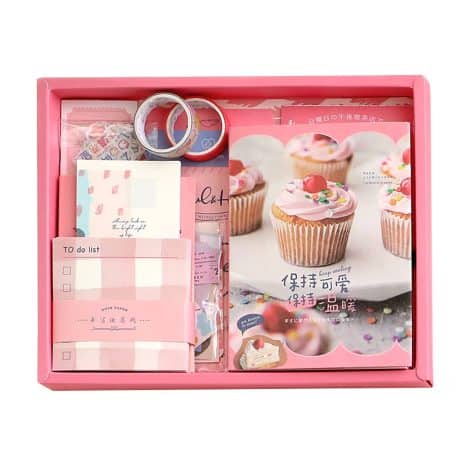 Set de accesorios vintage para scrapbooking y journaling con cuaderno A6 y pegatinas decorativas en rosa.